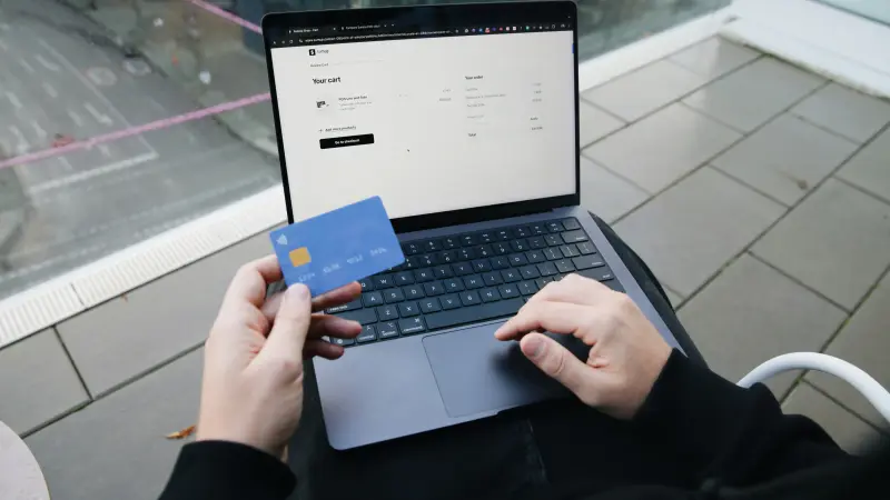 Online alışveriş sepetinde kartla ödeme yapan kişi ve dizüstü bilgisayar